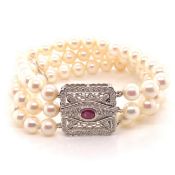 A THREE ROW CULTURED PEARL BRACELET COMPLETE WITH A PRECIOUS WHITE METAL, RUBY AND DIAMOND CLASP