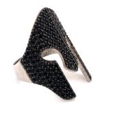 A PRECIOUS WHITE METAL AND BLACK CUBIC PAVE SET RING IN THE FORM OF A SPARTAN HELMET. FINGER SIZE