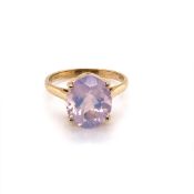 A MODERN 9ct HALLMARKED GOLD LADIES DRESS RING. THE OVAL GEMSTONE IN A RAISED FOUR CLAW SETTING.