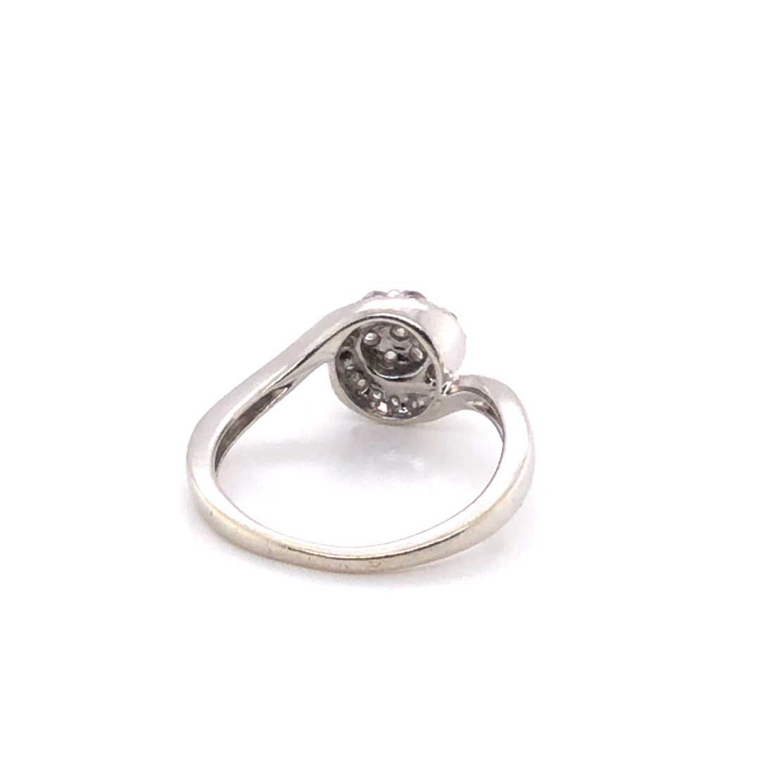 AN 9ct HALLMARKED WHITE GOLD DIAMOND SET CLUSTER TWIST RING. APPROX DIAMOND WEIGHT 0.25cts. FINGER - Image 2 of 3