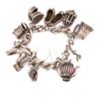 A HALLMARKED SILVER VINTAGE CHARM BRACELET, COMPLETE WITH AN ASSORTMENT OF SILVER CHARMS, AN