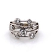 AN 18ct WHITE GOLD AND DIAMOND RAIN DANCE STYLE RING. THE FIVE BANDS OF WHITE GOLD SUSPENDING