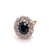 A VINTAGE 9ct HALLMARKED GOLD SAPPHIRE AND DIAMOND CLUSTER RING. THE OVAL SAPPHIRE IN A TWELVE