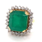 AN 18ct YELLOW GOLD EMERALD AND DIAMOND RING. THE LARGE CENTRAL EMERALD SURROUNDED BY A FRAME OF