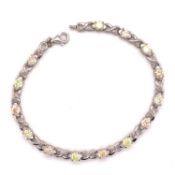 A SILVER PEACH AND YELLOW CUBIC ZIRCONIA LINE BRACELET. LENGTH 19cms. WEIGHT 9.6grms.