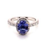 A TANZANITE,DIAMOND AND PLATINUM RING. THE OVAL CUT TANZANITE IN A FOUR CLAW SETTING APPROX 1.51cts,