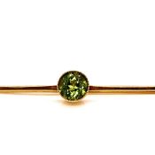 AN ANTIQUE 9CT GOLD STAMPED PERIDOT BAR BROOCH THE STONE MEASURING 7.3mm DIA LENGTH 6cm WEIGHT 2.