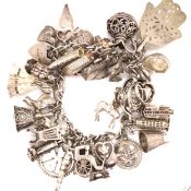 A VINTAGE SILVER CHARM BRACELET COMPLETE WITH PADLOCK CLASP AND ATTACHED SAFETY CHAIN, CHARMS TO