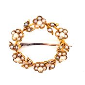 AN ANTIQUE 15CT YELLOW GOLD STAMPED AND SEED PEARL INSET GARLAND BROOCH WITH PIN BACK 2.8cm DIA