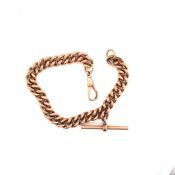 A 9ct ROSE GOLD CURB BRACELET WITH ATTACHED T-BAR. EACH CURB LINK STAMPED WITH THE 375 COMMON