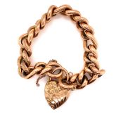 AN ANTIQUE ROSE GOLD HALF LINK ENGRAVED CHARM BRACELET WITH AN ATTACHED PADLOCK STAMPED 9ct.