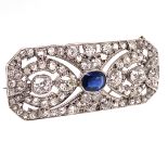 AN EDWARDIAN SAPPHIRE AND DIAMOND PANEL BROOCH. THE CENTRE OVAL MIXED CUT SAPPHIRE A MEDIUM TO