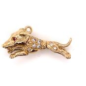 A YELLOW PRECIOUS METAL, ASSESSED AS FINENESS 375, ARTICULATED DOG PENDANT, INSET WITH RUBY EYES AND