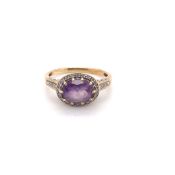 A PRECIOUS YELLOW METAL, AMETHYST AND DIAMOND DRESS RING. THE OVAL HORIZONTAL SET AMETHYST IN A