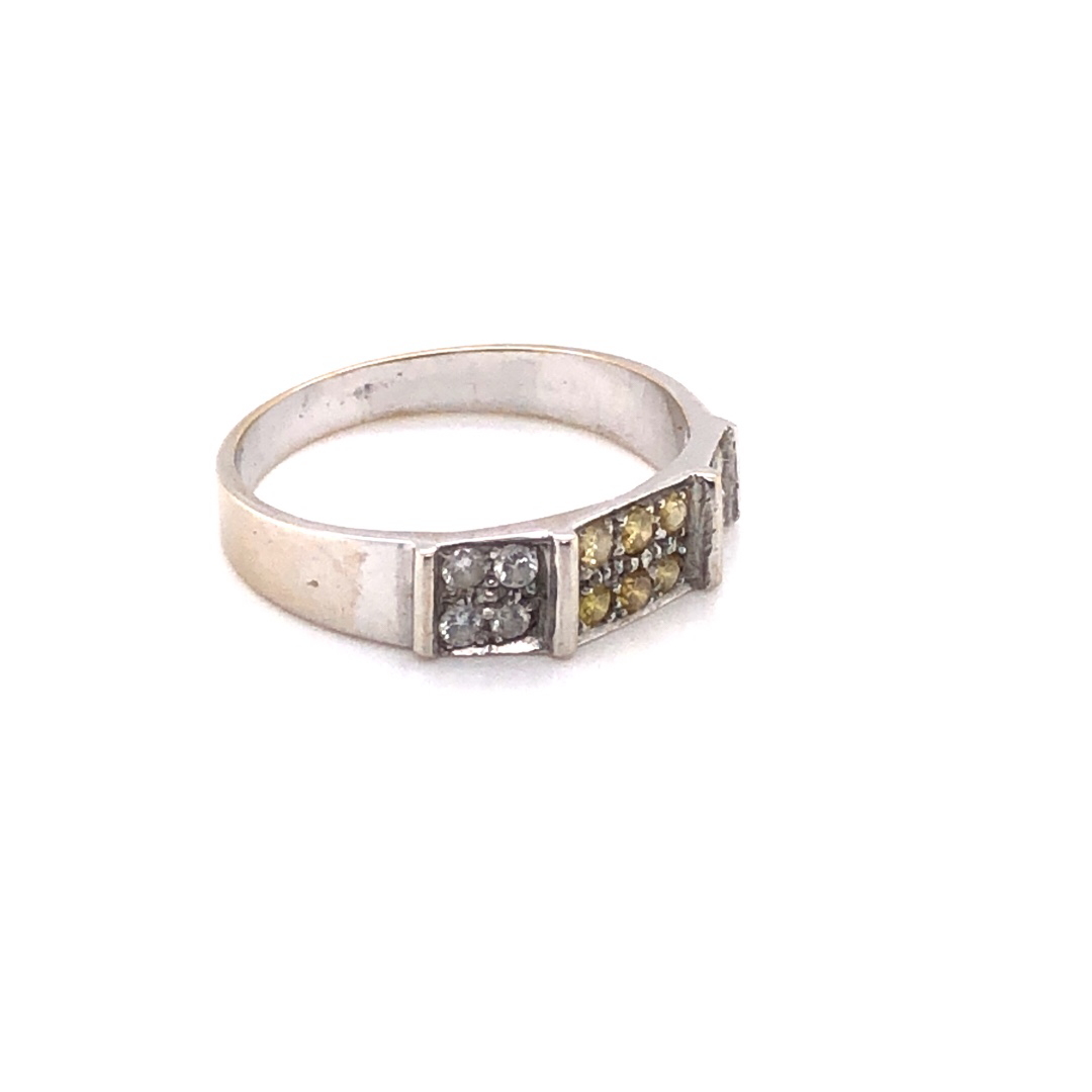 A PRECIOUS WHITE METAL AND DIAMOND RING. THE THREE PANELS CONSISTING OF PAVE SET YELLOW AND WHITE