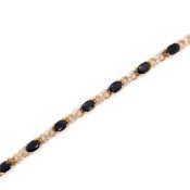 A 9ct HALLMARKED GOLD, SAPPHIRE AND DIAMOND LINE BRACELET. THE FOURTEEN OVAL SAPPHIRES IN FOUR