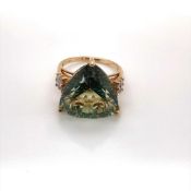 A 9ct HALLMARKED GOLD, AND GEMSTONE COCKTAIL RING. THE GREEN TRILLION CUT GEMSTONE IN A RAISED THREE