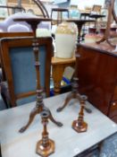 A PAIR OF MAHOGANY TRIPOD TORCHERES TOGETHER WITH A PAIR OF MAHOGANY CANDLESTICKS