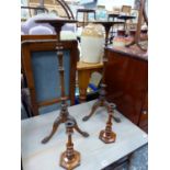 A PAIR OF MAHOGANY TRIPOD TORCHERES TOGETHER WITH A PAIR OF MAHOGANY CANDLESTICKS