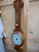 A VICTORIAN CARVED OAK ANEROID BAROMETER.