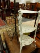 A THREE TIER IRON POT STAND,A PRICKET STYLE CANDLE STAND AND AN IRON BASKET.