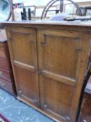 AN OAK PANELLED DOOR CABINET CONTAINING SIX SLIDES