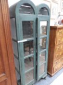 A BLUE PAINTED DOUBLE DOMED CABINET WITH GLAZED DOORS OVER SHELVES. W 80 x D 38 x H 191cms.