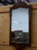 A WALNUT FRAMED RECTANGULAR MIRROR CRESTED BY A GILT SHELL