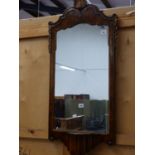 A WALNUT FRAMED RECTANGULAR MIRROR CRESTED BY A GILT SHELL