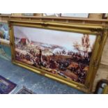 A DECORATIVE PICTURE IN A SWEPT GILT FRAME OF A BATTLE SCENE POSSIBLY WATERLOO. 90 x 182cms