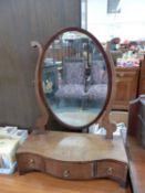 AN OVAL DRESSING TABLE MIRROR ON SERPENTINE FRONTED BASE WITH THREE DRAWERS