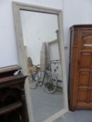 A LARGE WALL MIRROR WITH RUSTIC PAINTED FRAME.