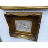 A DECORATIVE RELIEF PLAQUE OF WINGED PUTTI IN GILT FRAME