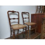 A SET OF FOUR CHAIRS WITH STAR ROUNDELS INLAID INTO THE TOP RAILS ABOVE CANED BACKS AND SEATS