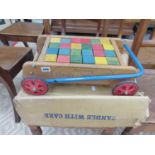 A VINTAGE TRI-ANG BABY WALKER BRICK TROLLY WITH ORIGINAL BOX.