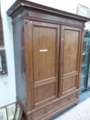 AN OAK WARDROBE WITH PANELLED DOORS ABOVE A DRAWER. W 145 x D 56 x H 208cms.