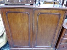 A MAHOGANY CUPBOARD WITH PANELLED DOORS ENCLOSING A SHELF
