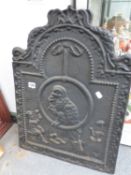 AN ANTIQUE CAST IRON FIRE BACK.