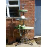 A WROUGHT IRON FOUR TIER PLANT STAND.