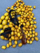 TWO COMPLETE STRANDS OF GRADUATED AMBER BEADS, TOGETHER WITH A QUANTITY OF LOOSE AMBER BEADS, AND