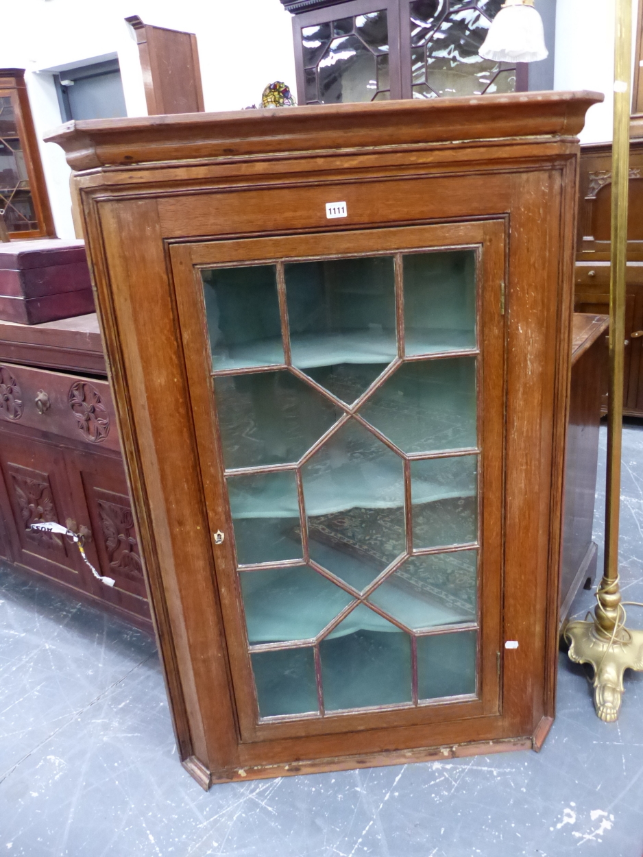AN ASTRAGAL GLAZED OAK CORNER CUPBOARD WITH PAINTED SHELVES