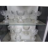 A SET OF NINE CUT GLASS GOBLET SHAPED VASES WITH HOLLOW FEET