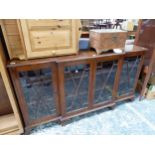 A CROSS BANDED MAHOGANY BREAKFRONT DISPLAY CABINET ON BRACKET FEET