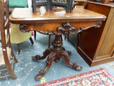 A VICTORIAN ROSEWOOD SWIVEL TOPPED GAMES TABLE ON GADROONED COLUMN AND FOUR FOLIATE CARVED FEET