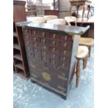 A CHINESE HARDWOOD CABINET WITH FIVE BANKS OF FIVE INSCRIBED DRAWERS OVER A BRASS MOUNTED CUPBOARD