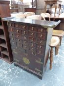 A CHINESE HARDWOOD CABINET WITH FIVE BANKS OF FIVE INSCRIBED DRAWERS OVER A BRASS MOUNTED CUPBOARD