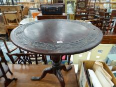 AN OAK TRIPOD TABLE WITH A LEAF BAND CARVED INTO THE CIRCULAR TOP