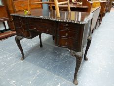 A MAHOGANY FIVE DRAWER TABLE, THE GADROONED EDGE TOP ABOVE LEATHER INSET WRITING SLIDE AND A