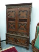 A 17th C. STYLE OAK WARDROBE WITH HANGING SPACE ABOVE TWO SHORT AND A LONG DRAWER