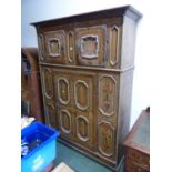 A GERMANIC FAUX BOIS PAINTED CABINET WITH TWO DOORS ABOVE A TALLER DOOR BETWEEN PANELS PAINTED